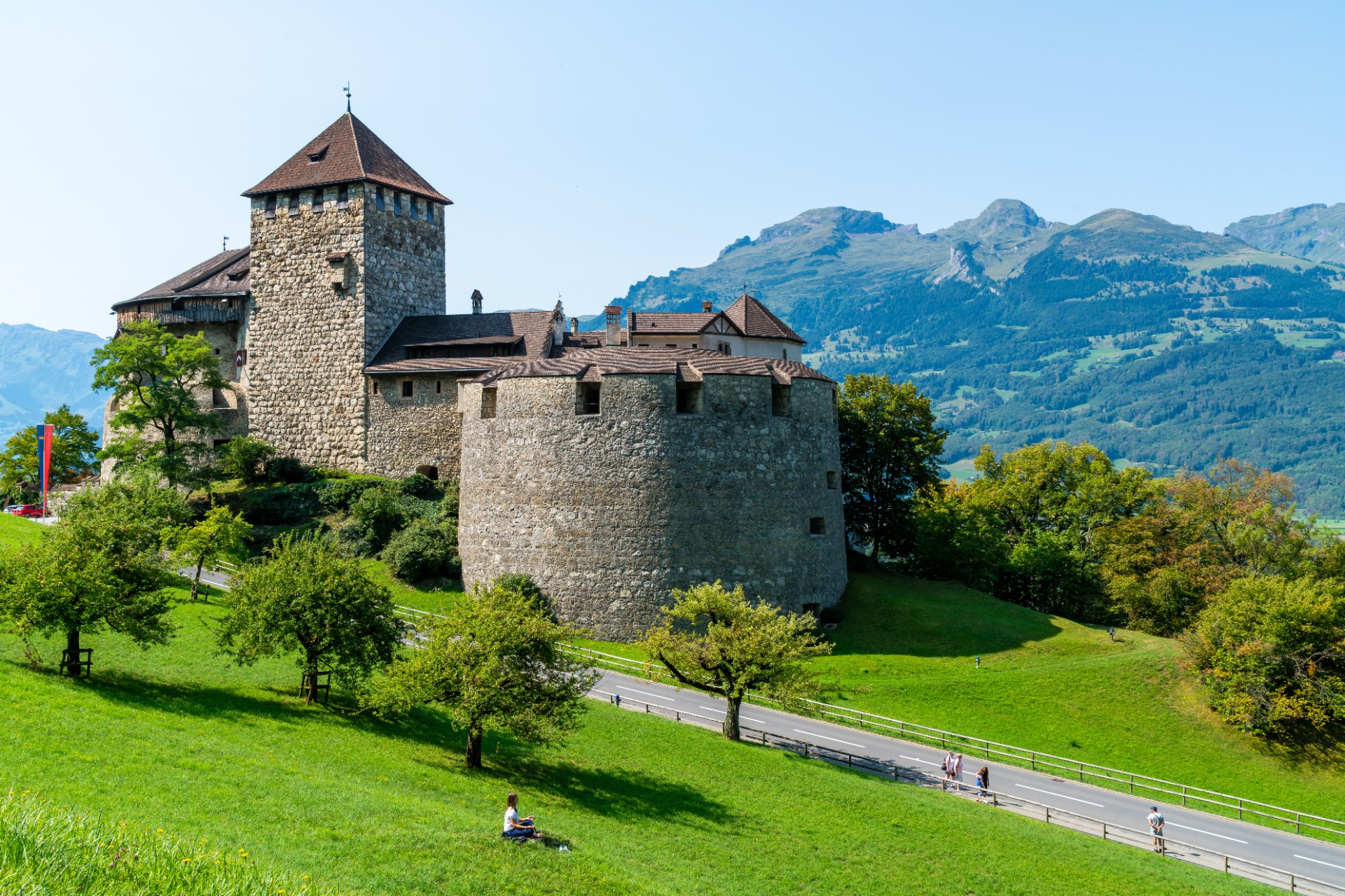 Schloss Vaduz auf einem grünen Hang vor den Bergen in Liechtenstein