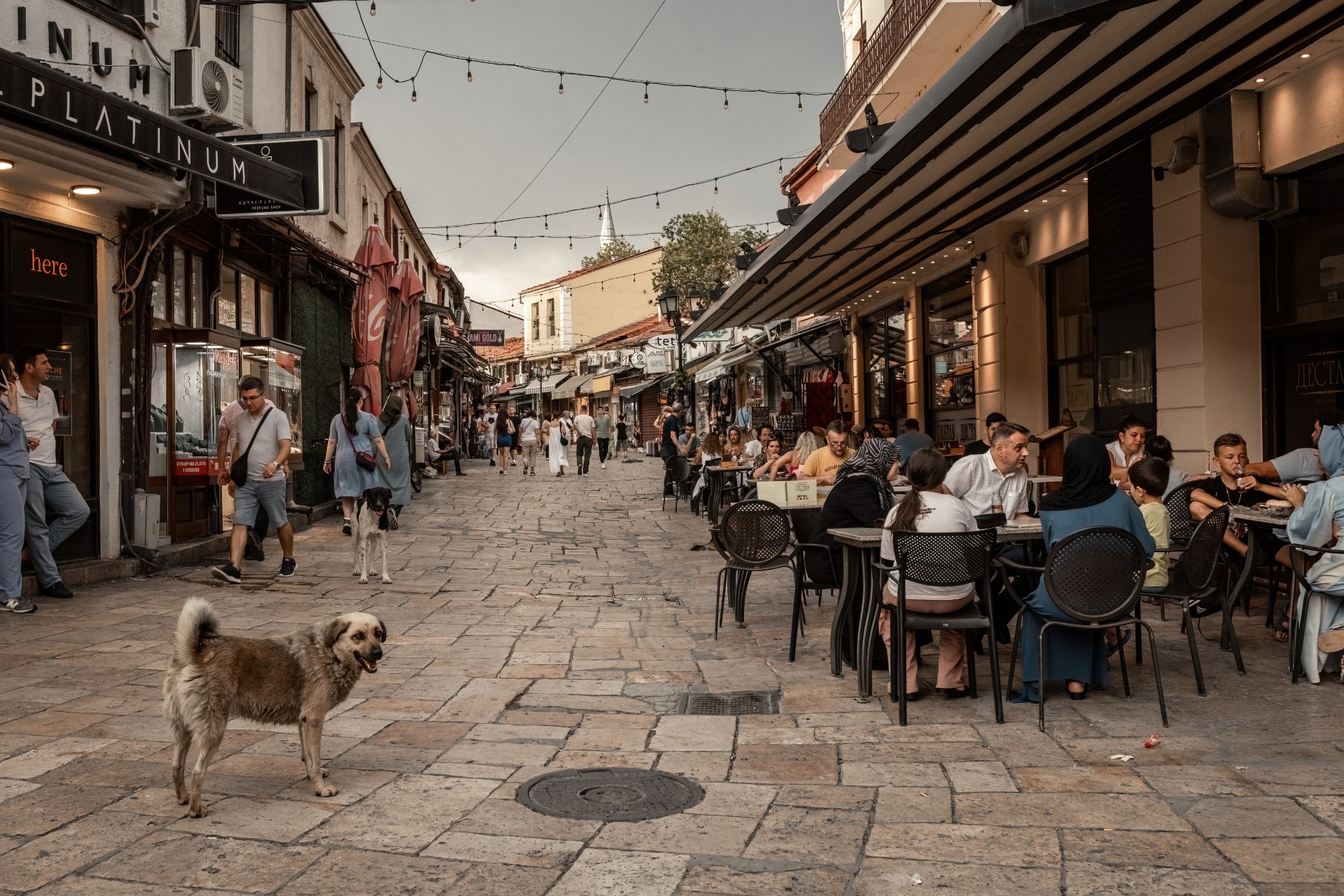 Menschen in Straßencafés in einer schmalen Marktgasse in der Altstadt von Skopje